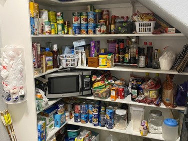 Before photo of cluttered under the staircase pantry. Prior to ClutterFree PHD personal home detailing services in Boerne TX, San Antonio, Hill Country Texas, and virtual services across the USA.